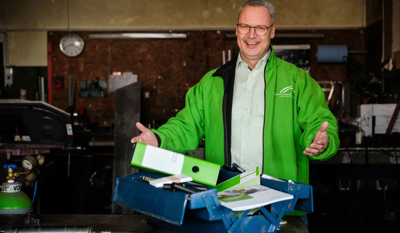 Arne Bär mit dem Führungskoffer in einer Werkstatt