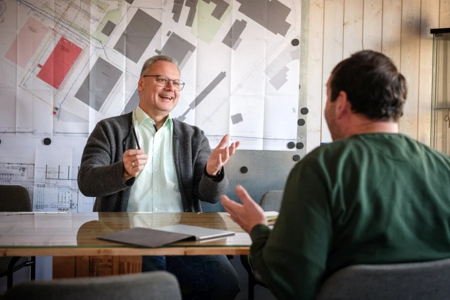 Arne Bär im Gespräch mit einem Handwerker am Besprechungstisch