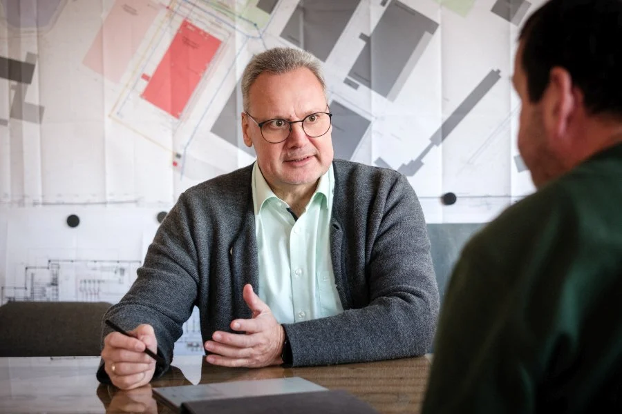 Arne Bär im Gespräch mit einem Handwerker am Besprechungstisch
